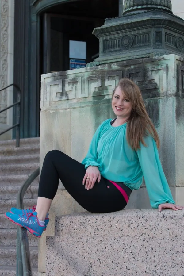 Brett Lyle seated on stone steps, smiling, in a sea-glass green blouse